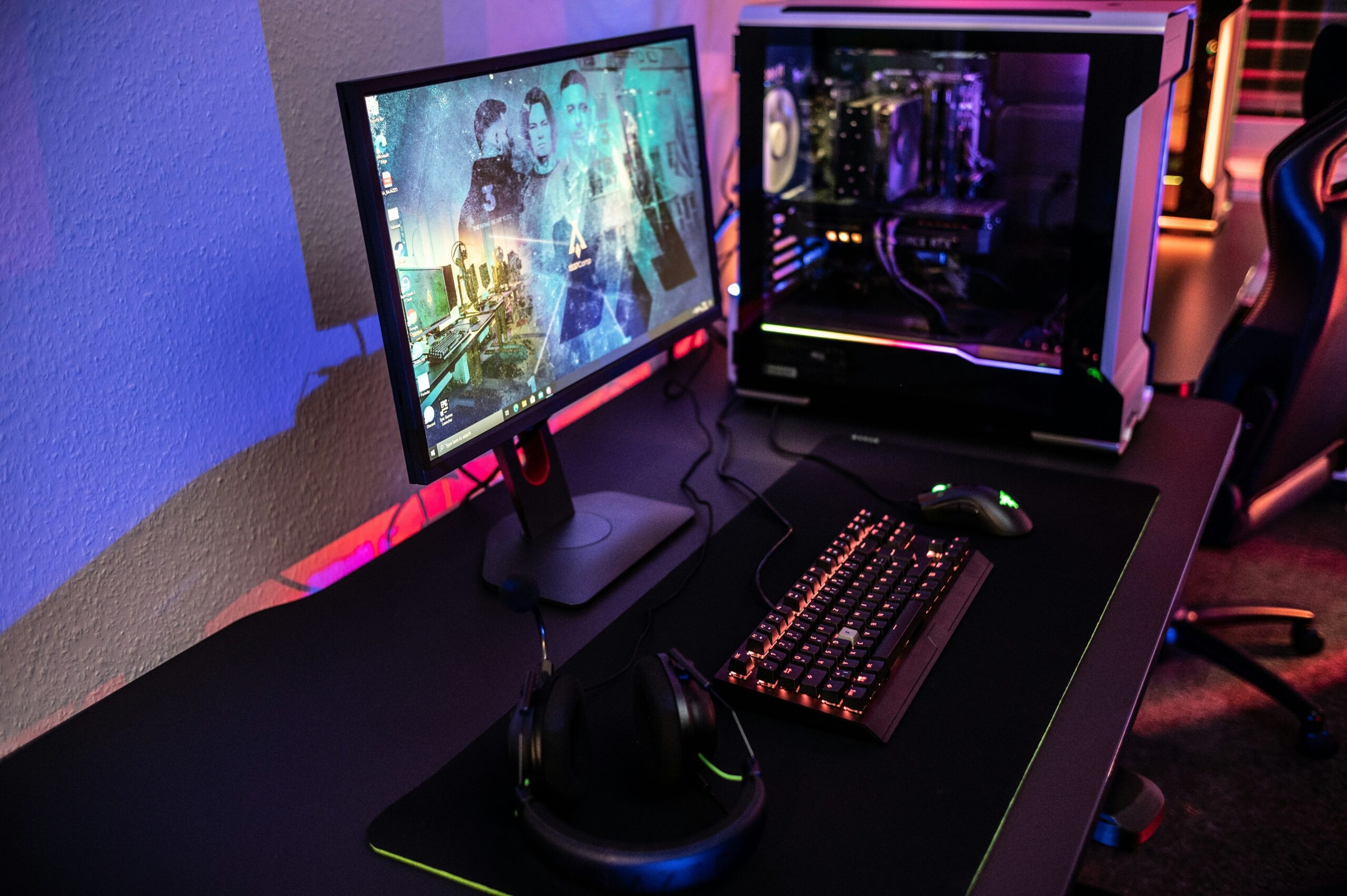 Player seated at desktop computer while using phone next to them